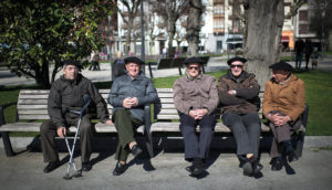 ancianos sentados en un banco en la calle.