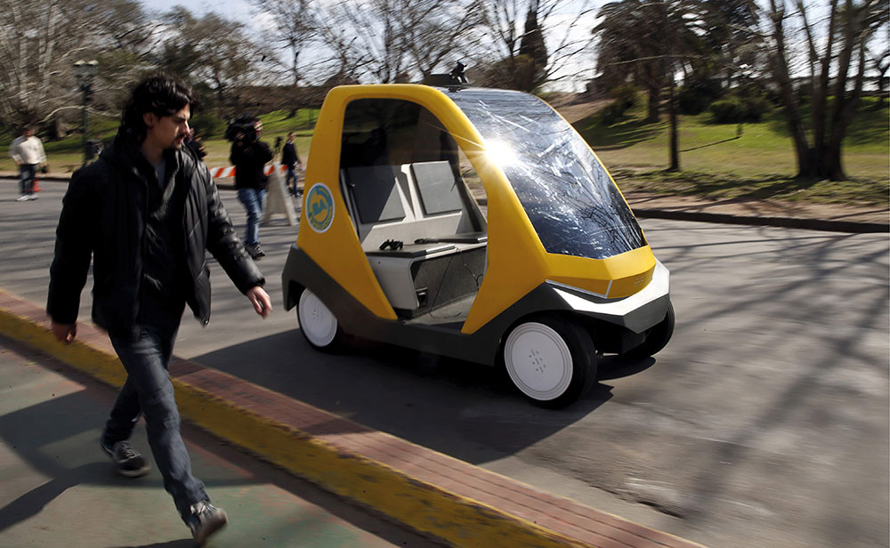 Ein Mann läuft parallel zu einem Prototyp eines autonomen Elektrofahrzeugs in Buenos Aires.