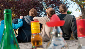 Jóvenes de espaldas en un botellón.