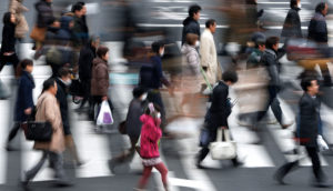 Gente caminando en un paso de cebra de una ciudad.