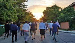 Grupo de personas caminando por la calle al amanecer.