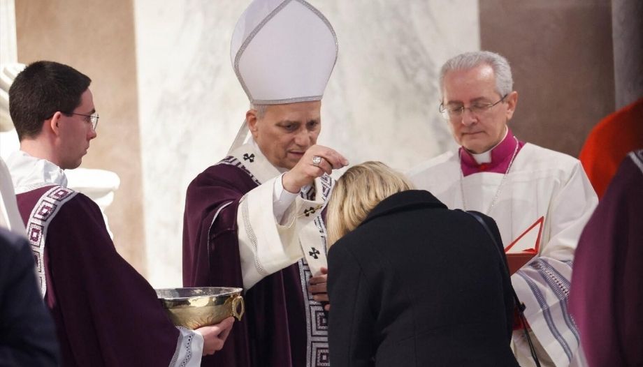 El Papa impone la ceniza a una mujer.