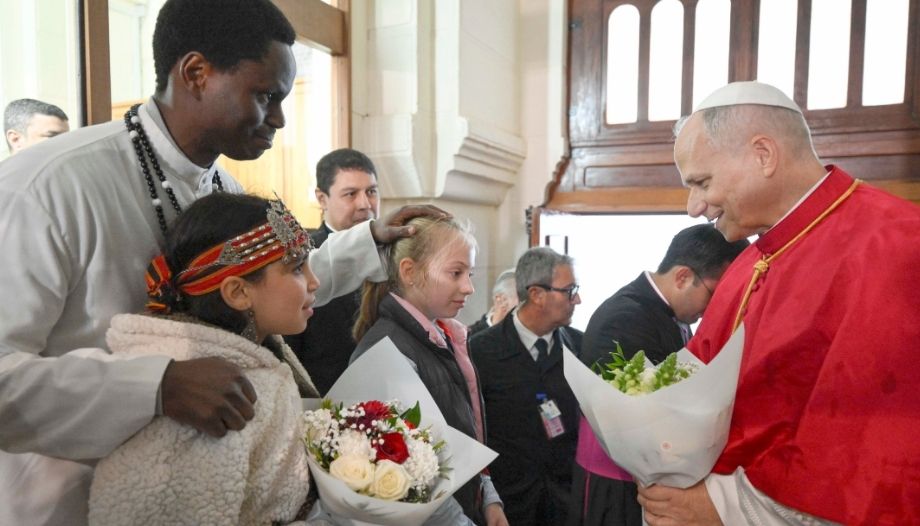 El Papa saluda a un hombre y dos niñas en la basílica católica de Argel.
